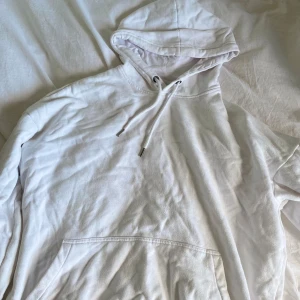 Vit hoodie från YOURTURN - Säljer en klassisk vit hoodie från YOURTURN med huva och dragsko. Tröjan har en stor magficka och är perfekt för en avslappnad stil. Mjuk insida och normal passform.