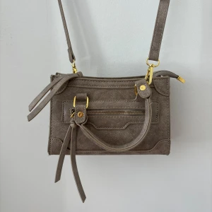 Axelremsväska - Beige väska med gulddetaljer