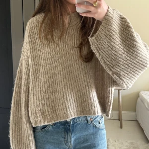 Beige stickad tröja från Gina Tricot - Säljer en beige stickad tröja från Gina Tricot som har en lite oversized passform med långa ärmar. Tröjan är i väldigt fint skick då den knappt är använd!☺️