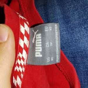 Röd Ferrari t-shirt från Ferrari  - Säljer en grå t-shirt från Calvin Klein med svart logga tryckt över bröstet. Klassisk rund halsringning och korta armar. Perfekt för en stilren och enkel look