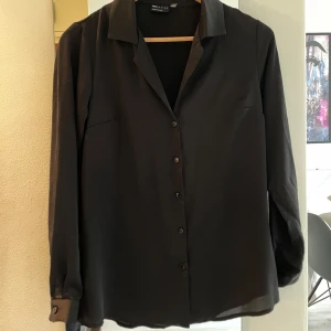 Svart skjorta - Fin skjorta från Asos, använd 1 gång. Den är i storlek 32 men skulle säga att den är mer som en 34:a