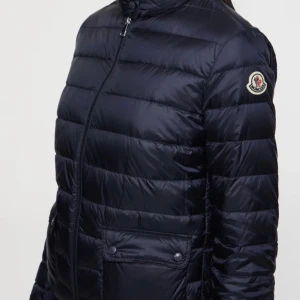 Svart dunjacka från Moncler, SKRIV PEIVAT FÖR BILDER - Säljer en svart dunjacka från Moncler med quiltad design och dragkedja framtill. Jackan har två stora fickor med knappar och en hög krage.  SKRIV PRIVAT FÖR BILDER