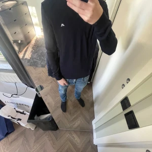 Mörkblå långärmad tröja från J.Lindeberg - Säljer en blå långärmad tröja från J.Lindeberg med diskret logga på bröstet och ärmslutet. Tröjan har en klassisk passform och är tillverkad i mjukt material som passar perfekt till jeans. 