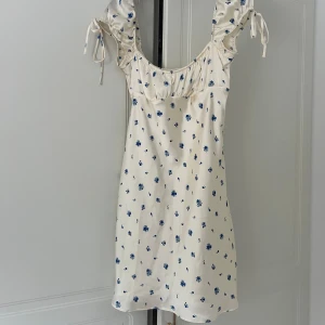 Vit blommig kortklänning från Zara - Supersöt vit kortklänning från Zara med blått blommönster. Använd 2 gånger 