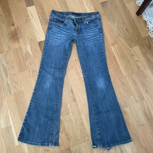 Blåa jeans  - Supersnygga midrise bootcut jeans i färgen blå! Vintage och går inte att få tag på längre! 7 , midja: 38 cm, midjehöjd: 21 cm, innerben: 79 cm