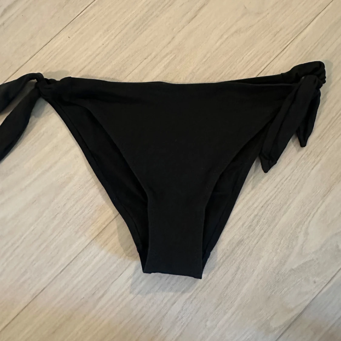 Svarta bikiniunderdelar med knyt