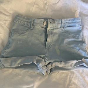 Ljusblå jeansshorts  - Har en tyvärr en blekningsfläck på sig! Man kan se på bilderna. Shortsen är i storlek 152 men jag skulle uppfatta storleken som en xs