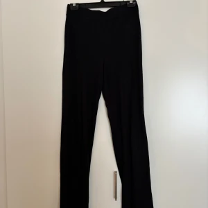 Svarta ribbade byxor från NA-KD XS - Svarta ribbade byxor från NA-KD i mjukt material. Byxorna har en relaxed passform med raka ben och resår i midjan. Perfekta för en chill och stilren look. Storlek XS.