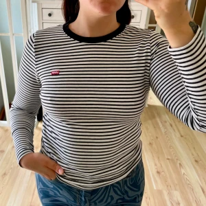 Levi's tröja  - Snygg långärmad tröja från Levi's i svartvitt randigt mönster. Tröjan har rund hals med svart kant och Levi's-logga på bröstet. Tillverkad i mjuk bomull! Använd väldigt lite!☀️Normal storlek!🌸