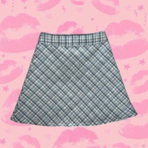 Rutig kortkjol från Sugar Thrillz XS - ((Hade också bytt mot en i storlek s eller m)) Supersöt A-linjeformad kortkjol från Sugar Thrillz i storlek XS. Kjolen har ett rutigt mönster i blått, vitt och beige, och är gjord i ett tjockare, strukturerat tyg med dragkedja bak. Perfekt för dig som gillar preppy vibes! Ungefärliga mått: Plat över midjebandet: 30 cm Längd: 42 cm Bredd nedtill: 58 cm