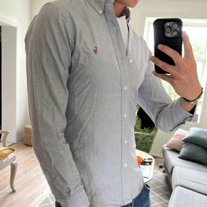 Ralph Lauren Skjorta - Över fet grå Ralph Lauren skjorta perfekt till alla sommarens stunder🙌 nypris runt 1700kr! Väldigt bra skick 