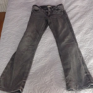 Grå jeans från Gina Tricot, stl 164 - Säljer ett par grå jeans från Gina Tricot i storlek 164. Jeansen har snyggt slitna detaljer och bakfickor med flätad dekorsöm. Klassisk femficksmodell med raka ben och normal passform. Perfekta till en cool vardagslook.