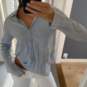 Ljusblå bomullsskjorta från Opus - Snygg ljusblå skjorta från Opus i 100% bomull. Tyget har ett diskret mönster som ger en extra touch. Perfekt till jeans eller kostymbyxor för en clean look.