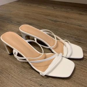 Vita sandaler med klack och tunna remmar - Säljer dessa helt nya, oanvända klackar då de ej kommer till användning. Pris går att diskutera 