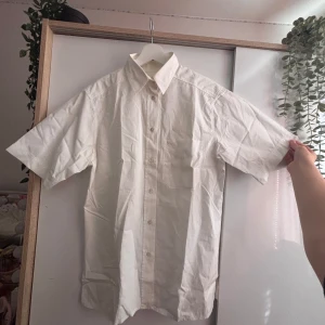 Kortärmad Skjorta Stenströms  - Vit kortärmad skjorta från Stenströms i klassisk modell med bröstficka och broderat S. Skjortan har knappar framtill och en snygg krage. Perfekt för dig som gillar stilrena och enkla plagg med premiumkänsla. Storleken är 36 men skjortan är bred så skulle nog säga att den passar storlek M eller i vissa fall kanske till och med L. Nypris: 1 000-1 799kr Helt oanvänd!