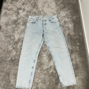 Ljusblå tapered jeans från Weekday - Säljer ett par ljusblå jeans från Weekday i modellen Barrel Relaxed Tapered. Jeansen har klassisk femficksdesign, hög midja och avsmalnande ben. Tillverkade i bomull och perfekta för en chill och stilren look.