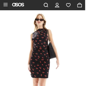 Svart körsbärsmönstrad kortklänning Asos - Supersöt svart kortklänning från Asos med röda körsbär över hela tyget. Ärmlös modell med tight passform. Aldrig använd, köpt för några år sedan för 300 kr. Hann inte skicka tillbaka den inom returdagarna, så säljer den nu för endast 150 kr.