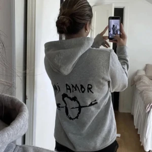 Grå mi amor hoodie - Grå hoodie från Mira Paris i mjuk bomull och en avslappnad passform. Jättefin och jätteskön!💗 Säljer pga att den inte kommer till användning så mycket längre. 