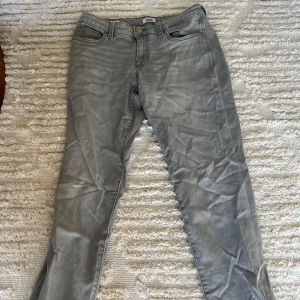 Grå slim jeans från Jack & Jones - Snygga grå jeans från Jack & Jones i slim fit-modell. Jeansen har klassisk femficksdesign, bälteshällor och dragkedjegylf. Perfekta för dig som gillar en smalare passform och stilren look.