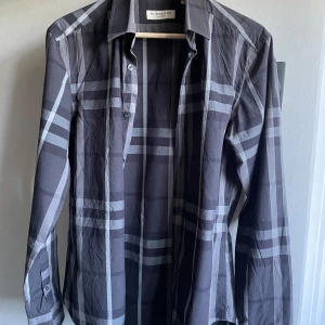 Burberry skjorta  - Äkta burberry skjorta som är unik och i väldigt bra skick. Storlek M men skulle säga att den kan passa S också. Byten kan vara intressant. Bara att skriva vid funderingar 😁 Skjortan är mörkare i verkligheten, blev skumt med ljuset på bilden