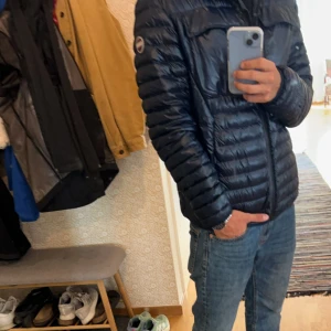 Blå dunjacka med dragkedja - Säljer en snygg blå dunjacka som är perfekt för hösten men även kyligare vinter dagar. Jackan är i nyskick och passar bra till både vardag och fest. Perfekt för höst och vinter!