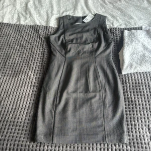 En grå medel lång klänning  - Det är en grå klänning,medel längd på klänningen, inte använd