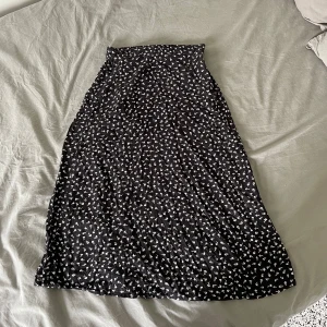 Blommig kjol - Jättesöt blommig kjol som går under knäna, från Monki!! Har använt några gånger, säljer pga använder aldrig kjol så den ligger bara och tar plats i min garderob! Resårband i midjan!!🥰