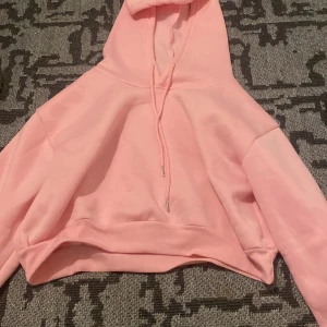 Rosa hoodie i mysigt material - Säljer en supermysig rosa hoodie som är perfekt för chilliga dagar. Den har en stor huva med dragsko och långa ärmar. Materialet känns mjukt och skönt mot huden. Passar perfekt till både vardag och mysiga hemmakvällar. 💖