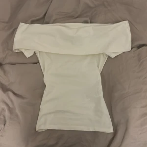 Vit offshoulder topp från Anna Field - Snygg vit offshoulder topp från Anna Field i ekologisk bomull. Perfekt för en stilren look med sin enkla design och mjuka material. Möts tyvärr bara upp!❤️