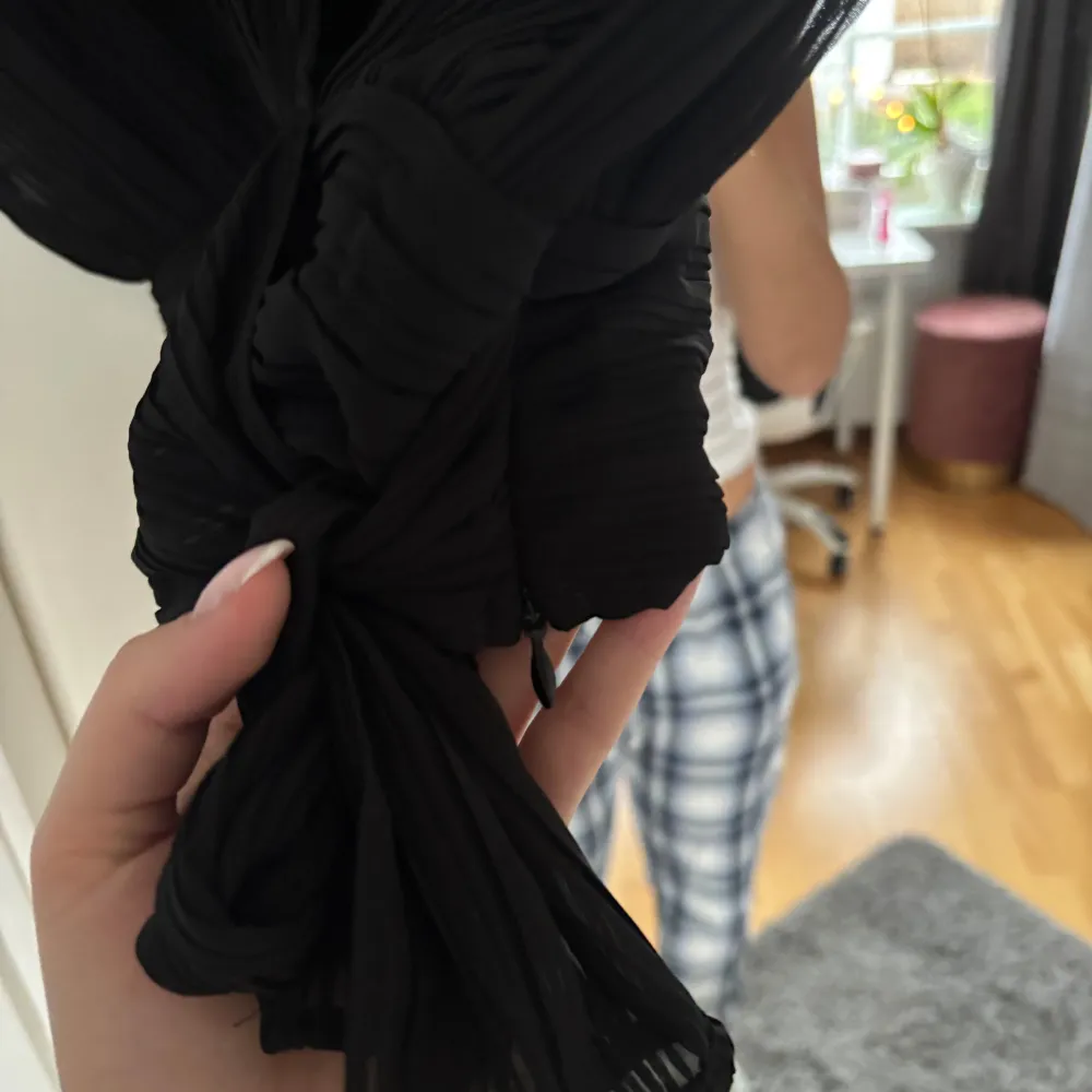 Snygg svart omlottopp från Zara med knytning i midjan. Toppen har en elegant v-ringning och är tillverkad i ett tunt plisserat material. Perfekt för utekvällar eller middagar💞. Yläosat.