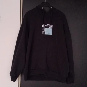 Svart hoodie från Reclaimed Vintage - Säljer en svart hoodie från Reclaimed Vintage med tryck av Vincent Van Gogh 1889. Tröjan har en stor färgglad bild på baksidan och text på framsidan. Perfekt för konstälskare som vill ha en unik stil.