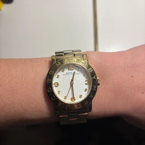 Guldfärgad klocka från Marc by Marc Jacobs - Snygg guldfärgad klocka från Marc by Marc Jacobs med vit urtavla och guldfärgade detaljer.