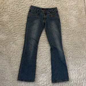 Lågmidjade jeans - Lågmidjade bootcut jeans från W-M-Y-H. Jag har satt i en extra knapp då byxorna blev förstora i midjan men de går lätt att ta bort, i övrigt inga defekter och som nya. Midjemått 39 och innerbenslängd 78. Skriv för fler frågor eller bilder🤍