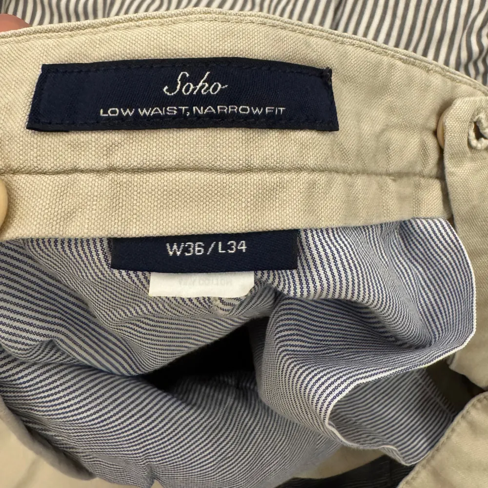 Säljer ett par stilrena beige chinos från GANT. Byxorna har låg midja och smal passform med knappstängning. Perfekta för en avslappnad men ändå uppklädd look.. Farkut & Housut.