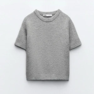 Grå stickad tröja från Zara - Säljer en stilren grå stickad tröja från Zara med korta ärmar. Perfekt för lager-på-lager eller som den är. Enkel och tidlös design som passar till många olika outfits.