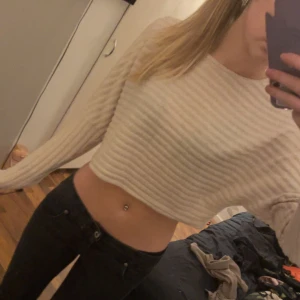 Beige ribbad croppad tröja - Säljer en beige ribbad tröja med croppad passform. Tröjan har långa ärmar.