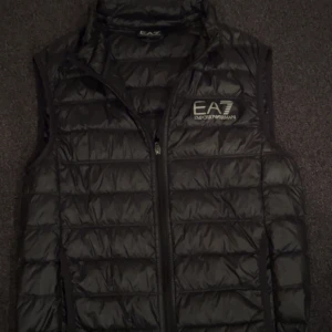 Svart dunväst från Emporio Armani - Säljer denna EA7 då jag städar ur min garderob. Riktigt bra skick och äkta. Storlek XS!