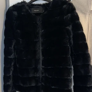 Svart pälsjacka från Vero Moda - Snygg svart pälsjacka från Vero Moda i storlek XS. ❤️🥰Jackan har en stilren design med långa ärmar och är perfekt för kyligare dagar. Den är mjuk och bekväm att bära. Säljer då jag använt den 1 gång och ingen mer gång beroende på att jag har massa andra jackor 💕köp gärna super fint skick vill få sålt då den bara hänger i min garderob 🥰🎄 passar även nu till våren❄️