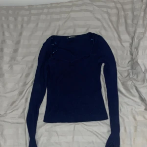 Mörkblå ribbad tröja från Gina Tricot - Snygg mörkblå stickad topp med hjärtformad ringning. Toppen är blå, ribbad och långärmad. Den har figurnära passform, slits vid ärmsluten och formstickade partier framtill från Gina Tricot 