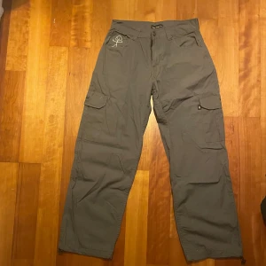 Gråa baggy/loose cargobyxor från Bsat - Säljer ett par grå cargobyxor från Bsat med baggy passform. Byxorna har flera praktiska fickor och är perfekta för en avslappnad stil. Midjemått W30.