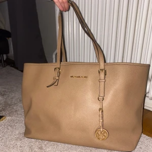 Michael kors Tote väska  - Fin stor Michael kors Axel väska i färgen brun med guldiga detaljer. I fint skick 