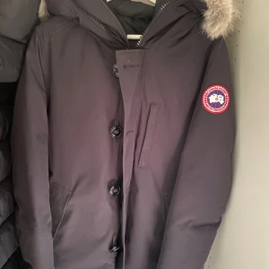 Canada goose jacka - Haft den sen i vintras fin jacka ganska varm, tar bara plats i garderoben så som det är nu. Riktigt fin päls, äkta såklart. Jackan är väldigt mörk marin blå.