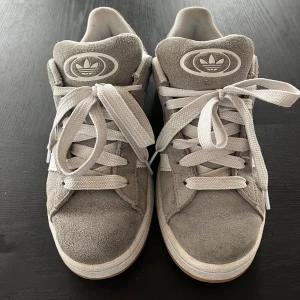 Adidas campus 00 grå  - Säljer mina Adidas campus eftersom att dom ej kommer till någon användning längre! Dom är användas till god del men har tagit hand om de bra så de är fortfarande i väldigt fint skick❤️ de är i storlek 38 2/3 men sitter som en 38/39