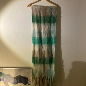 Stor randig halsduk med fransar - Stor mysig halsduk med randigt mönster i grönt och beige.