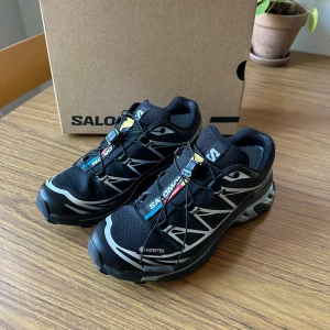 Salomon sneakers XT-6 Gore-Tex black/silver - Köpta i höstas och använda en gång i skogen, men tyvärr är de för små och jag behöver köpa en storlek större. Dessa är storlek EU 36 2/3 eller UK 4.  Säljes därför i mycket bra skick samt originalbox. Nypris är 2390 kr. Hämtas i Malmö eller fraktas inom Sverige!