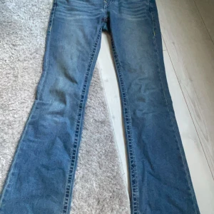Blå bootcut jeans från true religion - Snygga blå bootcut jeans från true religion köpta på jeansbolaget w26 säljer på grund av att dom är för stora för mig väldigt fina dom är även helt nya priset kan diskuteras vid snabb affär köptes för 1400 och inte använda mer än 4 gånger