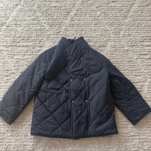 Svart quiltad jacka från Arket - Säljer nu min as snygga svarta quiltade jacka från Arket!! Enda tecken på användning är dom fläckarna man ser i bilden, som säkert går bort mer i en tvätt🩷🩷köpt för 1200.