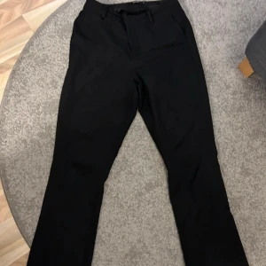 Svarta kostymbyxor - Eleganta svarta kostymbyxor med en klassisk passform. Perfekta för en stilren look. Är från bikbok i stl 38, finns några defekter så som hål i fickan men som inte syns och lite slitage vid byxänden. Nypris 499 säljer för 160!
