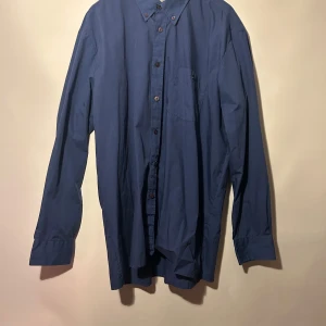 Blå skjorta från G. Fellini - Klassisk blå skjorta med långa ärmar och knappstängning. Skjortan har en bröstficka. Bra skick, skulle tro att det är storlek L, finns ingen lapp kvar.