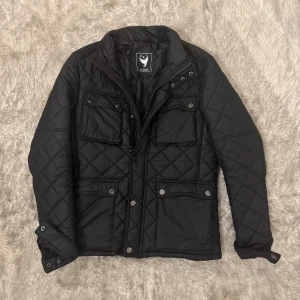 Mörkblå quiltad jacka  - Mörkblå quiltad dunjacka i storlek S, bra passform och varm. Ett litet hål vid armhålan innanför jackan annars är den i väldigt bra skick. Kontakta gärna om ni har några frågor eller funderingar gällande pris eller plagg